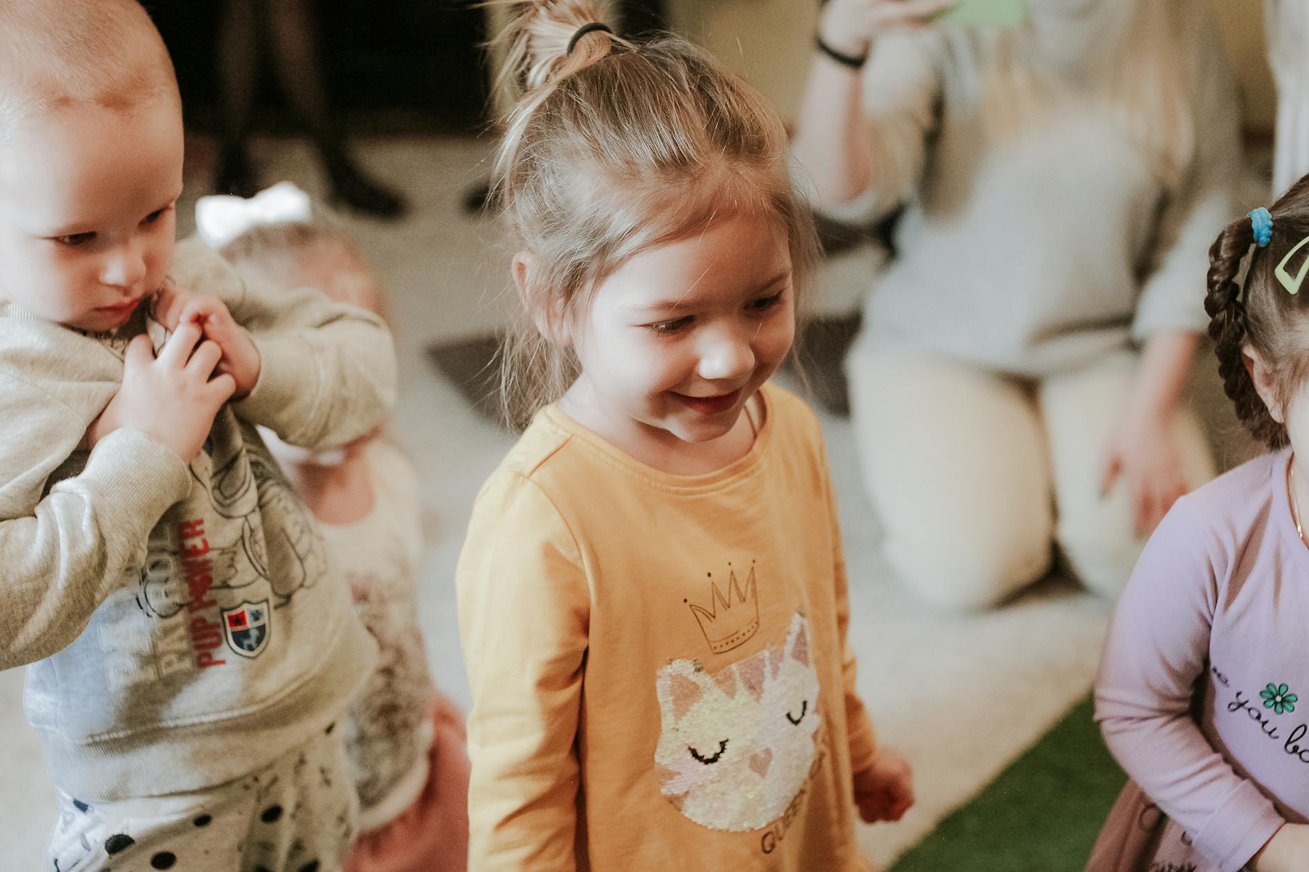 Uśmiechnięte małe dzieci bawią się razem zabawkami w sali przedszkolnej