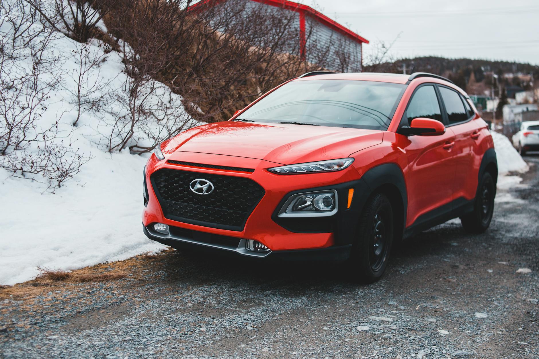 Czerwony SUV Hyundai zaparkowany na śniegu, widok z boku