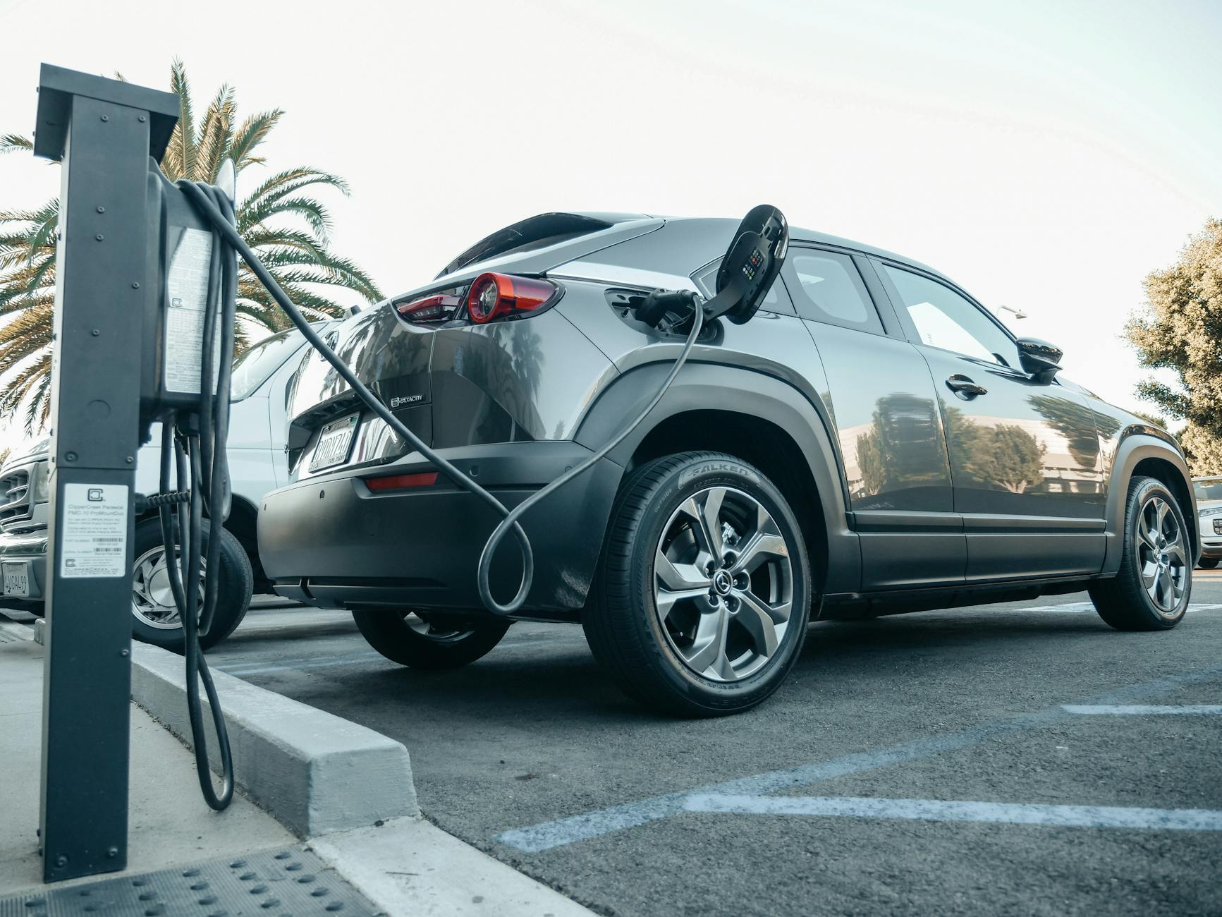 Elektryczny SUV ładuje się na zewnętrznej stacji w słoneczny dzień