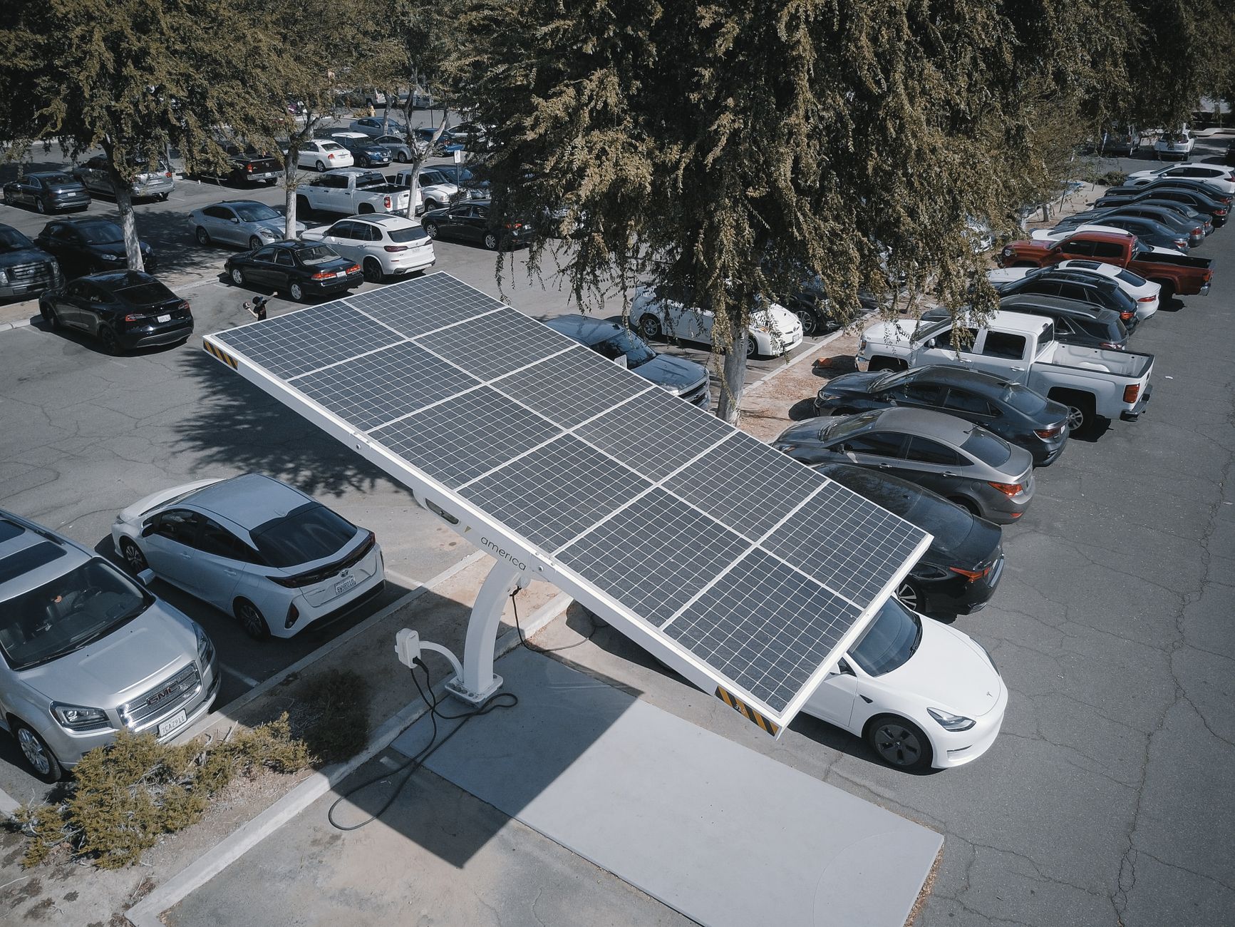 Elektryczne auta ładujące się na parkingu z panelami fotowoltaicznymi
