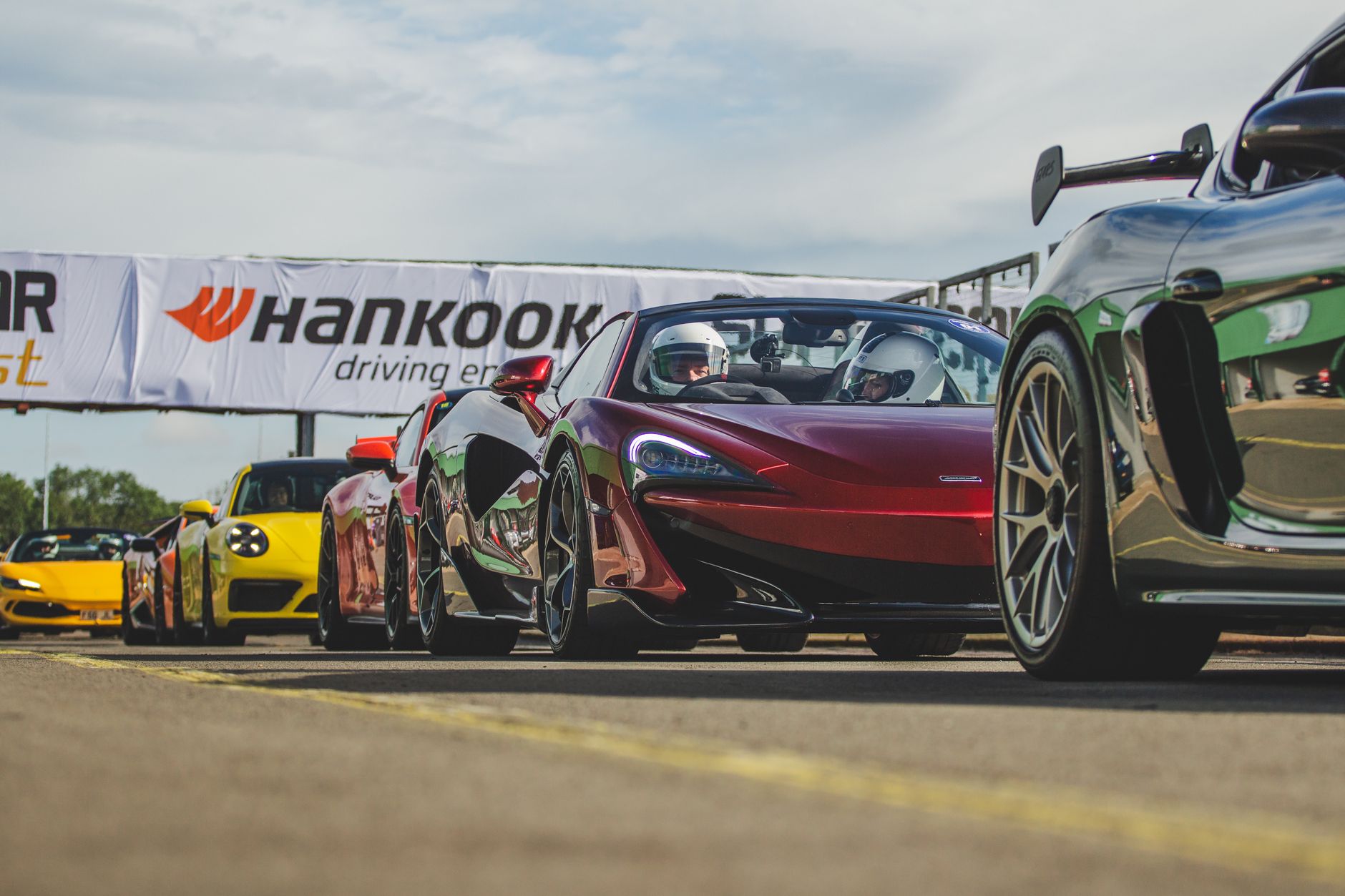 Linia sportowych Porsche 911 ustawionych na torze wyścigowym