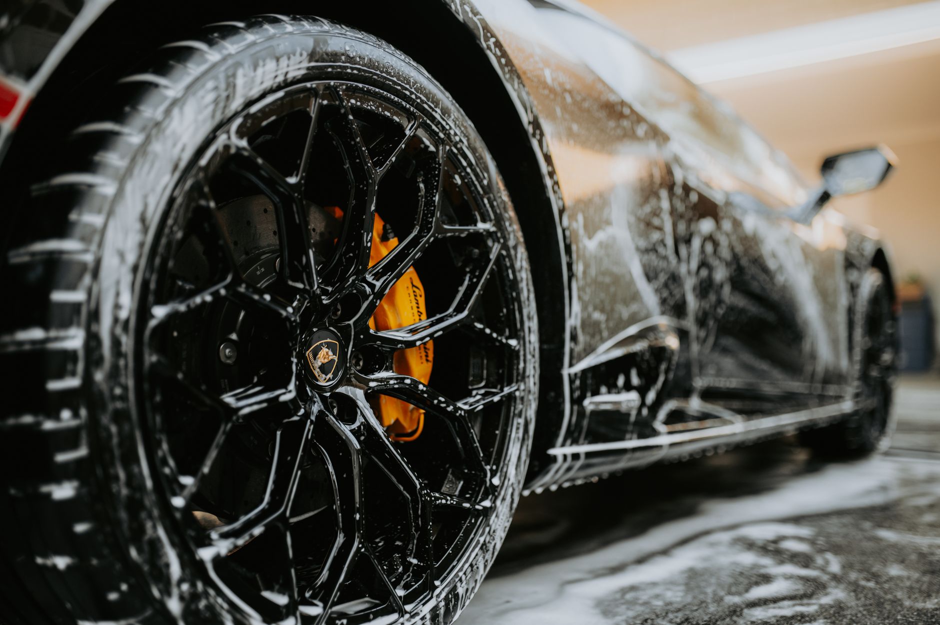 Zbliżenie na koło Maserati pokryte pianą podczas mycia auta