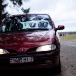 Czerwone Renault Scenic II na wiejskiej drodze