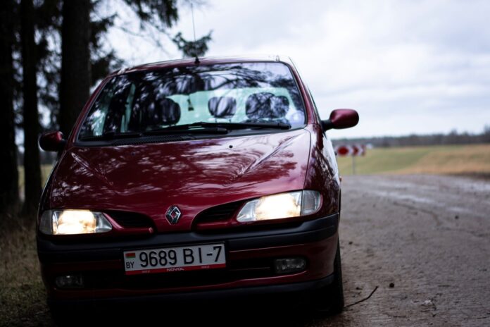 Czerwone Renault Scenic II na wiejskiej drodze Czerwone Renault Scenic II na wiejskiej drodze