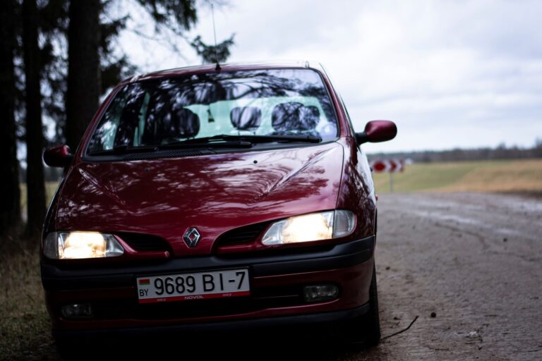 Czerwone Renault Scenic II na wiejskiej drodze
